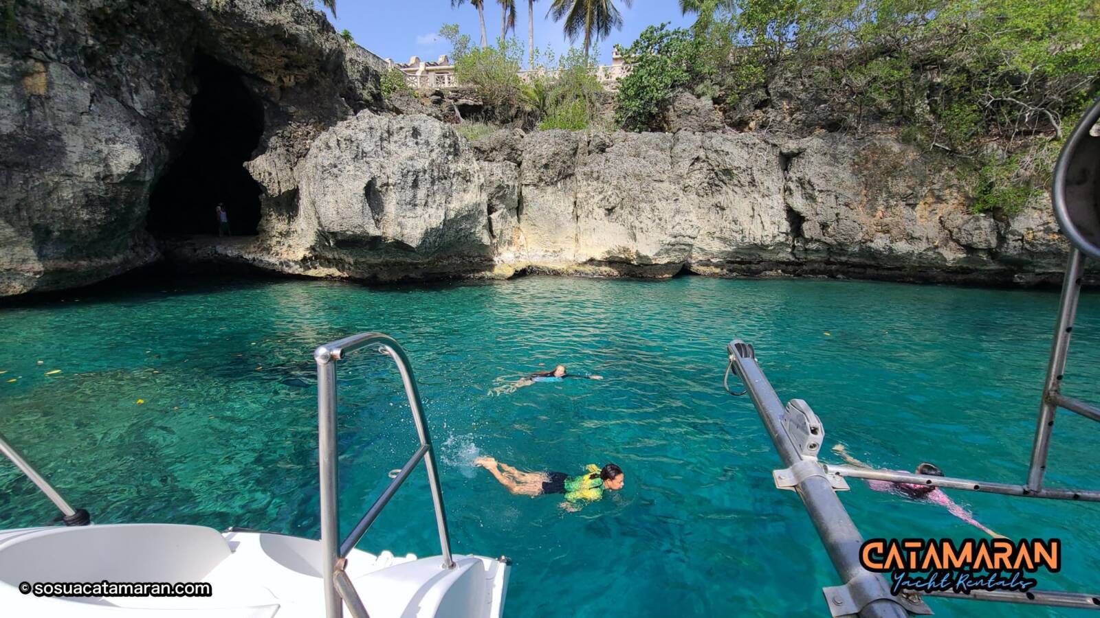 Guests swim by the cave at a Sosua beach